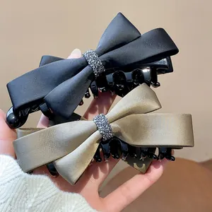 Détail des barrettes à cheveux en satin avec strass étincelants en noir et kaki