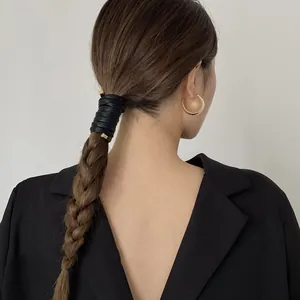 Fashionable minimalist black leather ponytail wrap accessory with elegant gold hoop earrings