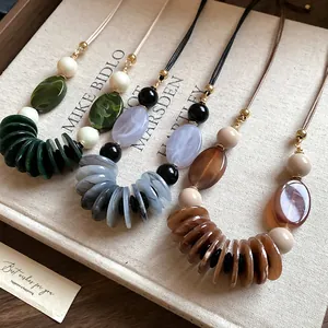 Gros plan de colliers en cuir vintage avec perles en résine ovales aux tons terreux