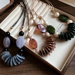 Vue détaillée de colliers de style ethnique avec cordons en cuir et perles décoratives