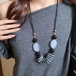 Gros plan détaillé du collier rétro style ethnique avec cordon cuir et perles ovales