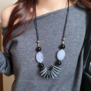 Gros plan d'un collier de style ethnique rétro avec perles grises et noires sur cordon