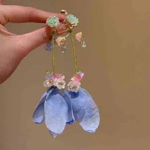 Detailed close-up of long floral tassel earrings with light blue chiffon petals.