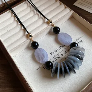 Vue détaillée d'un collier rétro ethnique avec perles marbrées sur un élégant cordon en cuir noir