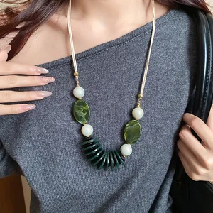 Gros plan d'un collier rétro ethnique avec pendentifs en marbre vert et perles