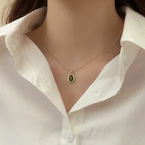 Primo piano di una collana vintage occhio di tigre placcata oro su una modella