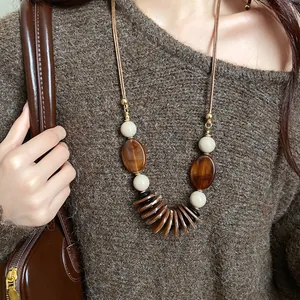 Détail d'un collier de style ethnique avec de grandes perles ovales brunes et des sphères