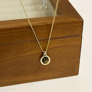 Primo piano di una collana vintage con pendente occhio di tigre e catena placcata oro.