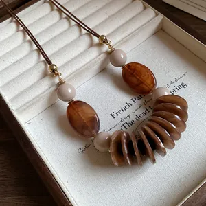 Vue détaillée d'un collier ethnique vintage avec cordon en cuir et perles d'ambre