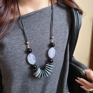 Détail du collier ethnique rétro avec cordon en cuir et perles grises