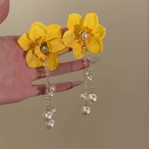 Elegant yellow fabric flower earrings featuring long white pearl and crystal bead tassels