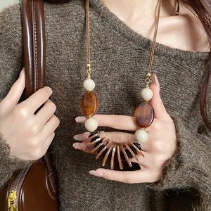 Vue détaillée d'un collier rétro ethnique avec cordon en cuir et perles d'ambre