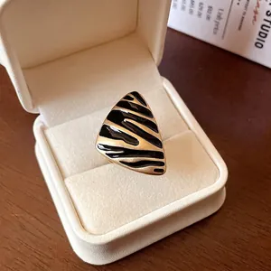 Anillo abierto vintage triangular dorado con rayas de esmalte negro en caja