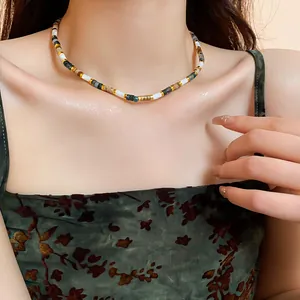 Close-up detail of a vintage minimalist beaded necklace elegantly worn on a model's neck