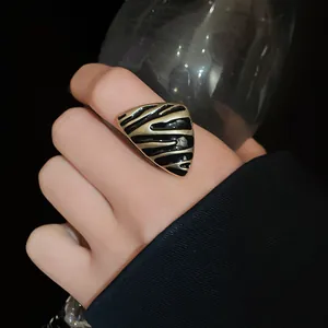 Detalle del anillo triangular vintage con esmalte negro y rayas doradas