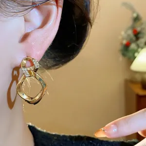 Elegantes pendientes de botón geométricos dorados con brillantes detalles de circonita