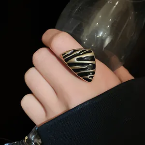 Primer plano detallado de un anillo vintage esmaltado triangular con rayas negras