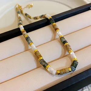 Detail view of retro stone bead necklace with polished gold spacers on jewelry display