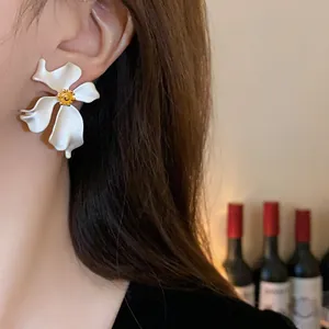 Primer plano de elegantes pendientes de flor blanca usados por una modelo