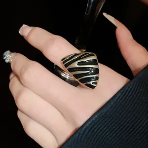 Vista detallada de un anillo triangular vintage con rayas de cebra en esmalte negro