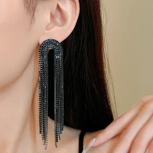 Close-up of elegant long tassel earrings with black rhinestones on an Asian model's ear.