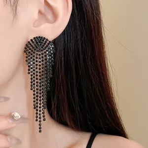 Detailed view of elegant black rhinestone long tassel earrings worn by a model