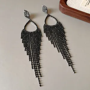 Close-up of sparkling black rhinestone tassel earrings with silver needle post.