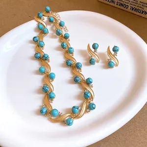 Vintage gold-tone jewelry set featuring turquoise-style beads and sparkling rhinestones