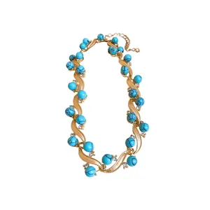 Vintage gold wavy chain necklace with turquoise beads and sparkling rhinestone accents.