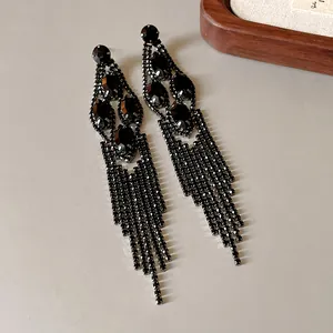 Close-up detail of elegant long tassel earrings featuring shimmering black rhinestones