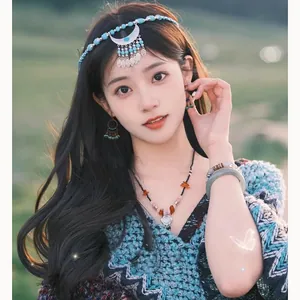 Gros plan de boucles d'oreilles ethniques à pompons et pierres irrégulières sur mannequin