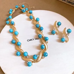 Close-up of vintage gold-tone necklace and earrings set with blue turquoise beads
