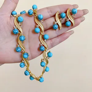 Close-up detail of vintage palace style gold necklace and turquoise stone earring set