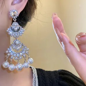 Macro shot of vintage fan-shaped earrings featuring elegant pearls and sparkling crystals
