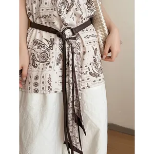 Elegante cintura in pelle marrone con sciarpa di seta stampata per un look retrò chic