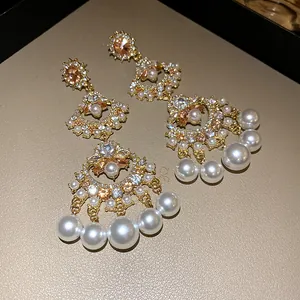 Detailed view of vintage fan-shaped tassel earrings with pearls and rhinestones