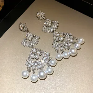 Close-up detail of vintage silver fan-shaped chandelier earrings with pearls and crystals