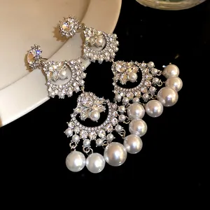 Detailed macro view of retro fan-shaped earrings with rhinestones and white pearls