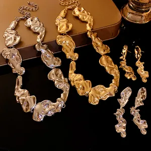 Vista dettagliata in primo piano di un set di gioielli in metallo fuso oro e argento.