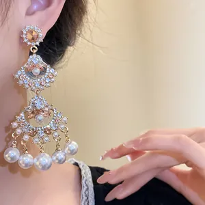 Macro view of vintage fan-shaped tassel earrings with pearls and rhinestones