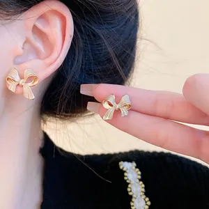 Primo piano dettagliato di eleganti orecchini a lobo a fiocco in zircone indossati da una modella