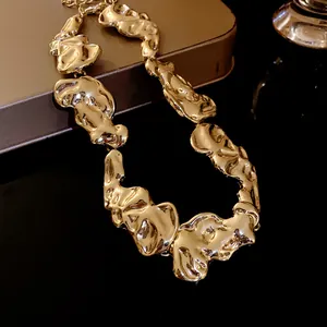 Primo piano di una collana in metallo dorato irregolare con finitura testurizzata