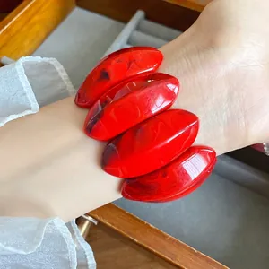 Bracciale in acrilico rosso marmorizzato con grandi maglie ovali per un look audace.