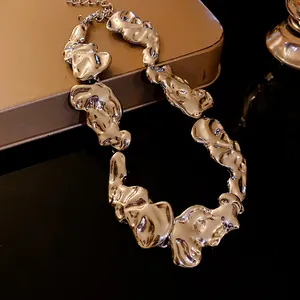 Primo piano di una collana metallica dorata con una trama irregolare di lava fusa
