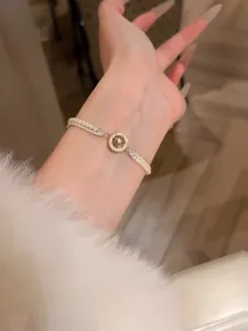 Bracelet de perles élégant avec étoile en zircone porté au poignet délicat d'une femme.
