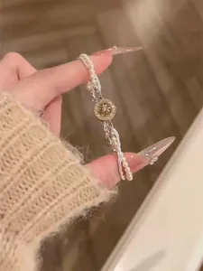 Détail d'un élégant bracelet en perles avec un pendentif étoile en zircon doré