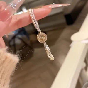 Gros plan d'un élégant bracelet en perles double couche avec une breloque en étoile