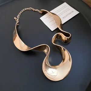 Vue détaillée du collier ras de cou en ruban de métal doré avec une finition brillante polie