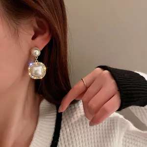 Dettaglio ravvicinato di eleganti orecchini di perle vintage con bordi in strass brillanti