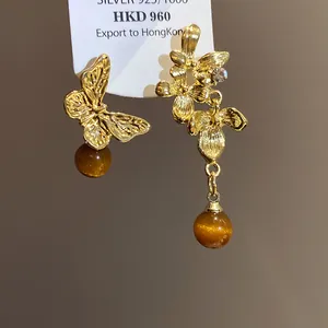 Orecchini asimmetrici a farfalla e fiori dorati con perle di ambra vintage